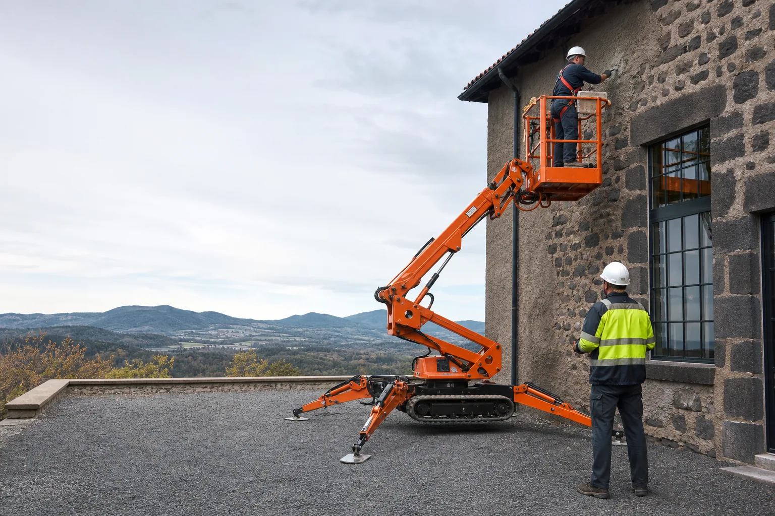 Une nacelle élévatrice orange intervient sur un bâtiment avec un technicien dans le panier et un opérateur au sol, dans le secteur de Le Puy-en-Velay.